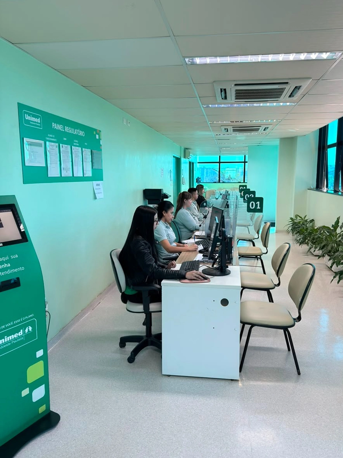 Atendentes do Laboratório Unimed Itapeva no balcão de atendimento